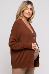 woman wearing a rust brown button-up maternity cardigan over a white top and showcasing her baby bump