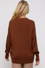 woman wearing a brown oversized maternity sweater with long sleeves and a relaxed fit, seen from the back