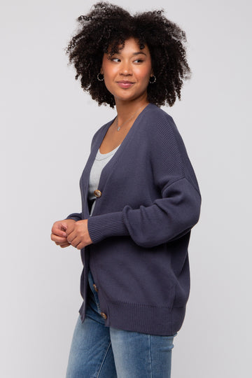 woman wearing a dark navy oversized cardigan with buttons, paired with a grey top and blue jeans