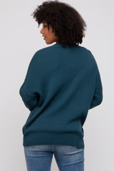 woman wearing a teal oversized sweater with ribbed texture and back view, paired with blue jeans