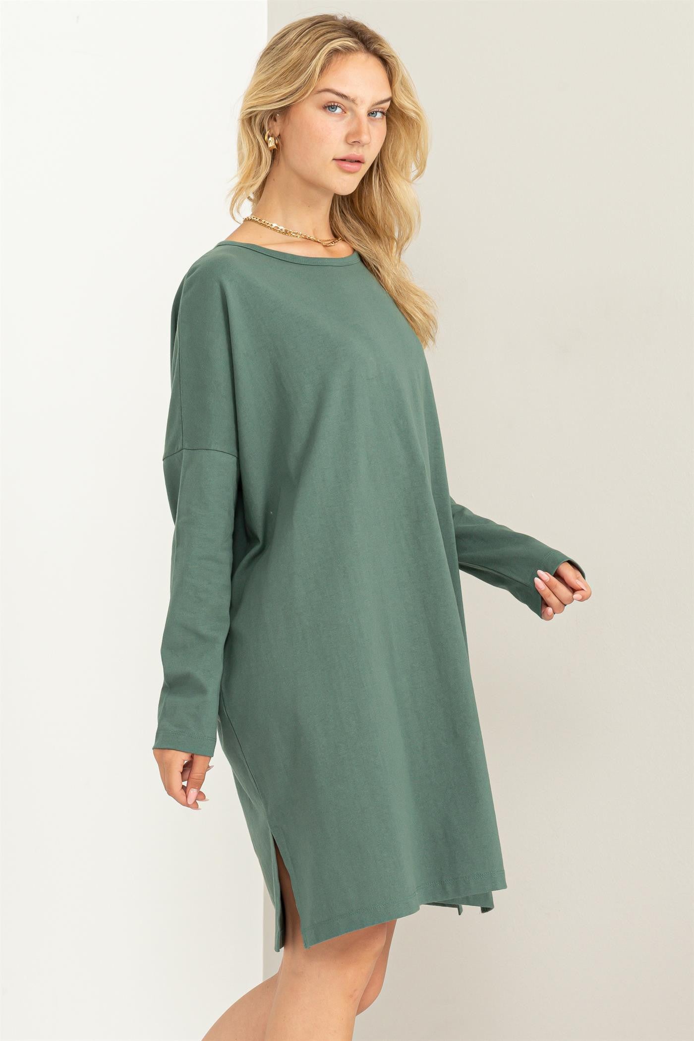 woman wearing a green oversized long sleeve dress with side slits and a relaxed fit