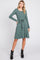 woman wearing a green long sleeve ribbed dress with a tie waist and black ankle boots
