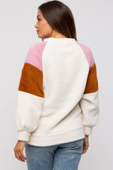 woman wearing a cream and multicolor fuzzy maternity pullover with balloon sleeves and a relaxed fit