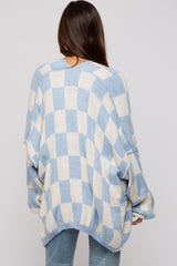 woman wearing a light blue and cream checkered oversized maternity sweater, viewed from the back