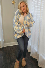 woman wearing a blue and white checked cardigan over a cream top with jeans and brown slippers