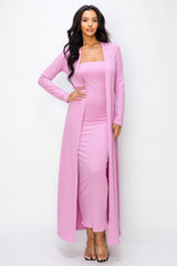 woman wearing a light pink ribbed two-piece dress with a long cardigan and strappy sandals