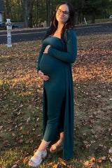 woman wearing a teal maternity dress with a long cardigan, showing her baby bump while standing outdoors