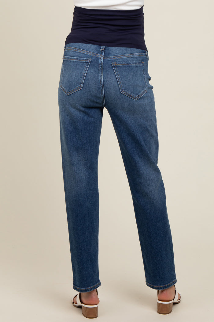 woman wearing a dark blue pair of maternity jeans, showing the back view with a stretchy waistband