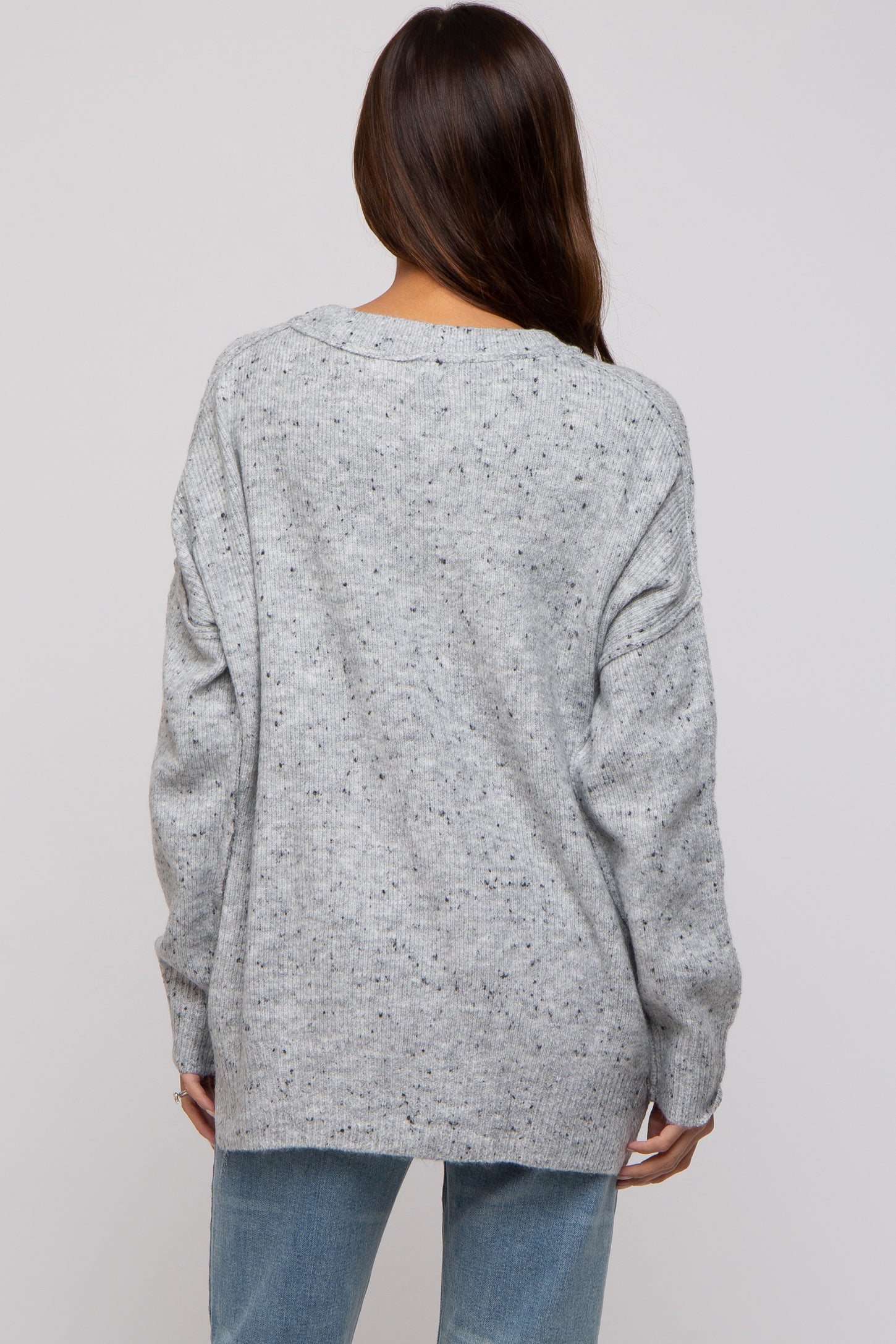 woman wearing a loose grey knit maternity sweater with a relaxed fit and dropped shoulder seams, back view