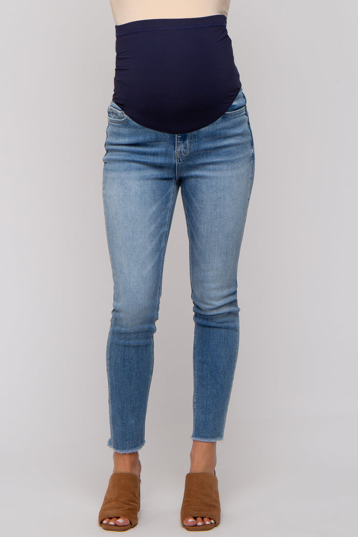 woman wearing a navy blue maternity belly band with light wash skinny jeans and brown slip-on sandals
