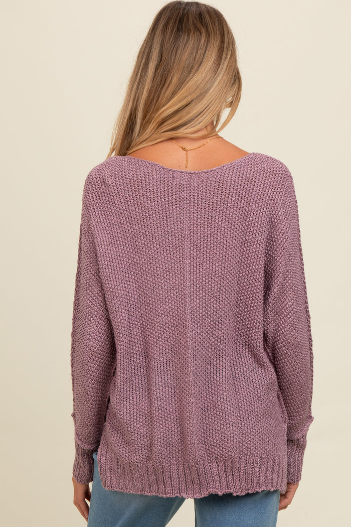 woman wearing a mauve oversized maternity sweater with a relaxed fit and ribbed hem, showing the back view