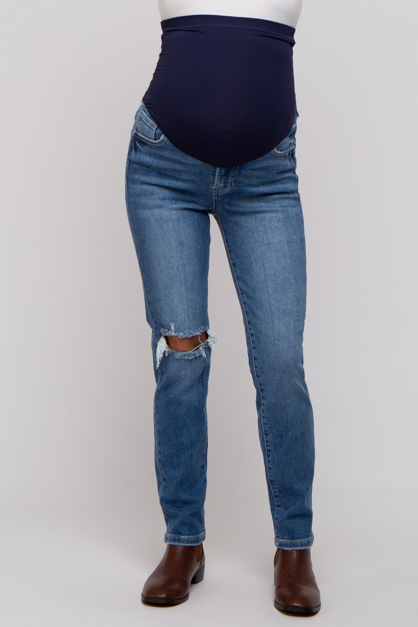 woman wearing blue maternity jeans with a distressed knee and a dark blue over-the-bump waistband