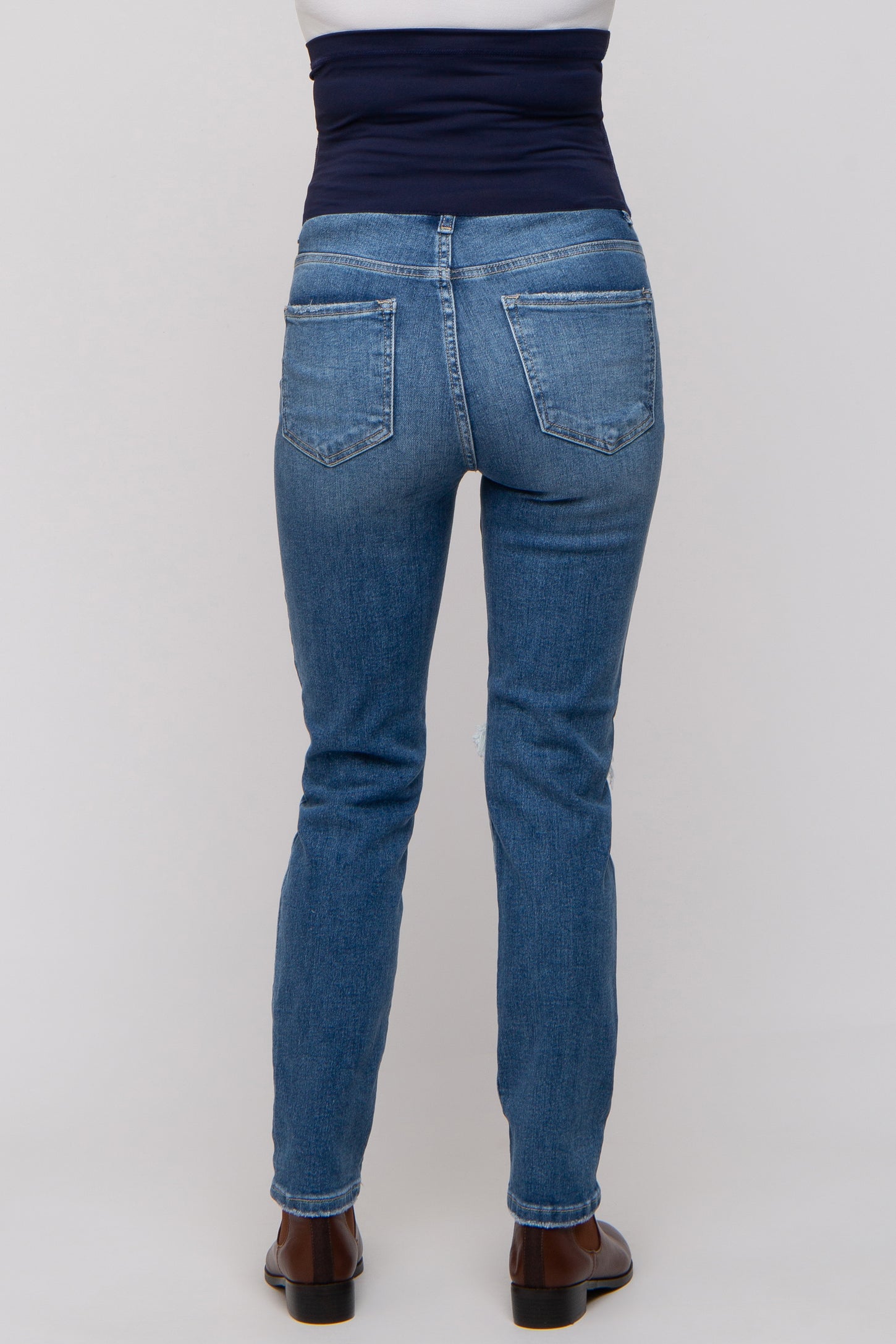 maternity wear blue skinny jeans with a dark blue over-the-belly waistband, shown from the back