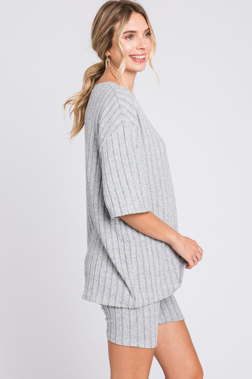 woman wearing a gray ribbed oversized t-shirt and matching shorts, smiling and posed sideways