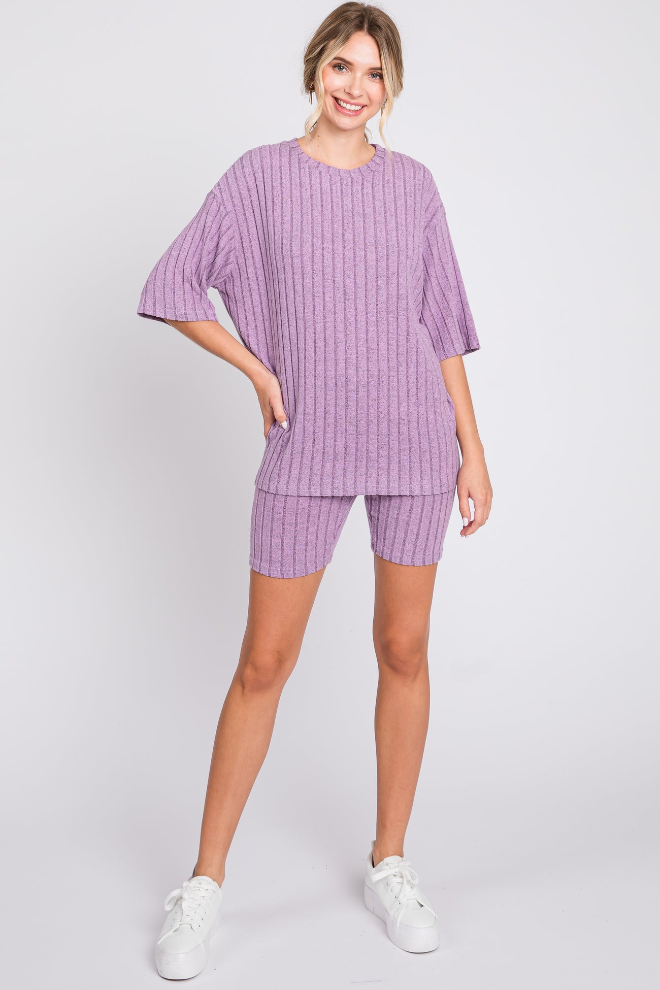 woman wearing a lilac ribbed short sleeve top and matching shorts with a relaxed fit and white sneakers