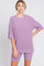 woman wearing a ribbed purple oversized t-shirt and matching shorts