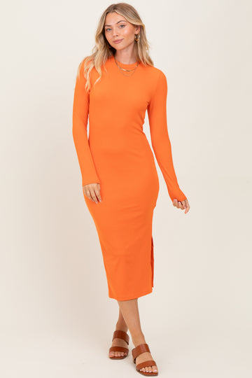 woman wearing a bright orange long sleeve ribbed midi dress with side slits and a fitted silhouette