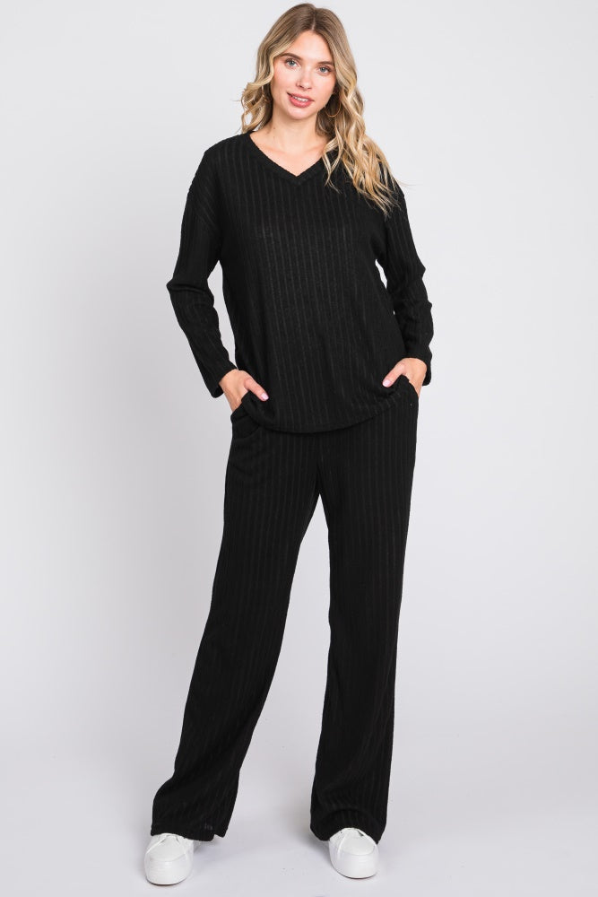 woman wearing a black ribbed long sleeve top and matching wide-leg pants with pockets