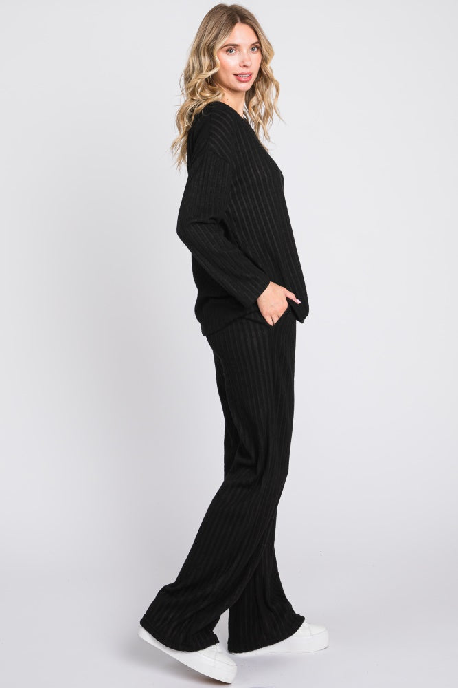 woman wearing a black ribbed knit loungewear set with a loose fit and wide leg pants
