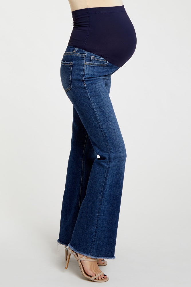 woman wearing dark blue maternity flared jeans with a comfortable waistband and visible baby bump