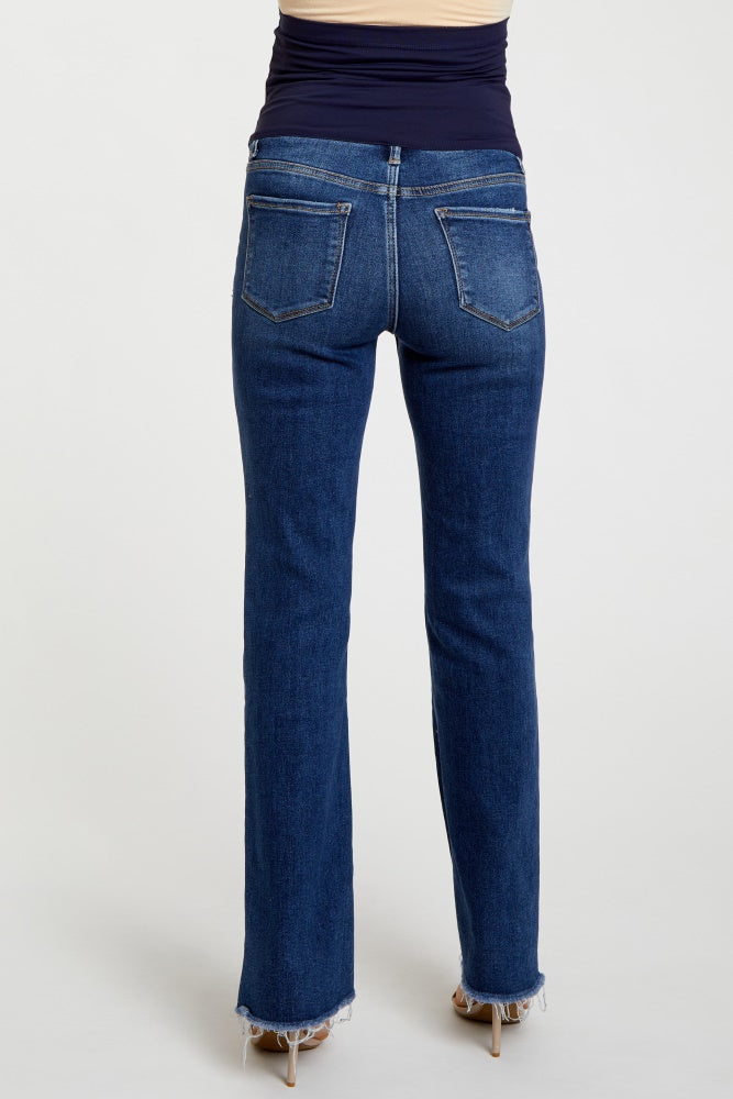 woman wearing dark blue maternity jeans with a bootcut style and frayed hem from the back