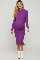 woman wearing a long sleeve purple maternity dress that hugs her baby bump, styled with white ankle boots