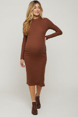 woman wearing a brown long sleeve maternity dress with a fitted silhouette and visible baby bump