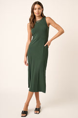 woman wearing a dark green sleeveless midi dress with side pockets and a relaxed fit