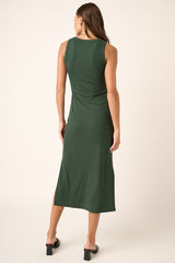 woman wearing a sleeveless dark green midi dress with a side slit, shown from the back