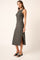 woman wearing a gray sleeveless midi dress with side slits and styled with black heeled sandals