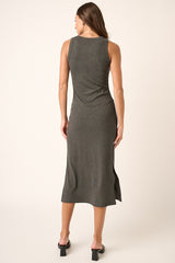 woman wearing a sleeveless gray midi dress with a side slit, shown from the back