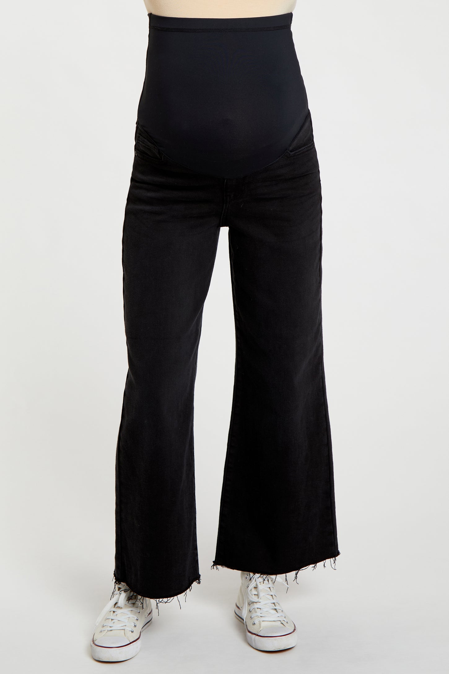 woman wearing black flared maternity jeans with a high waistband and frayed hem