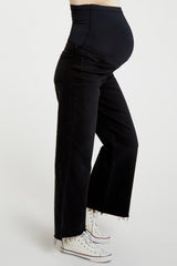 woman wearing black maternity wide-leg jeans with a stretchy waistband and visible baby bump