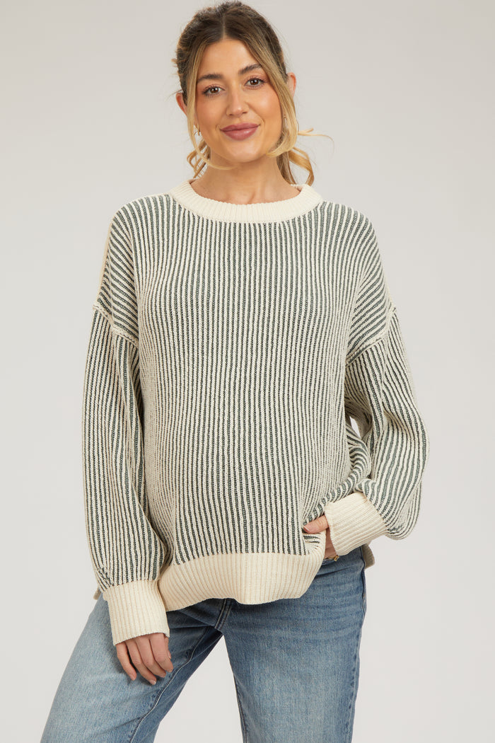 woman wearing a striped maternity sweater in green and cream with a relaxed fit and oversized sleeves