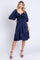 woman wearing a navy blue puff sleeve dress with ruching and a tiered hem