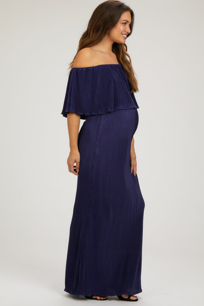 woman wearing a navy off-the-shoulder maternity maxi dress with a layered ruffle and visible baby bump
