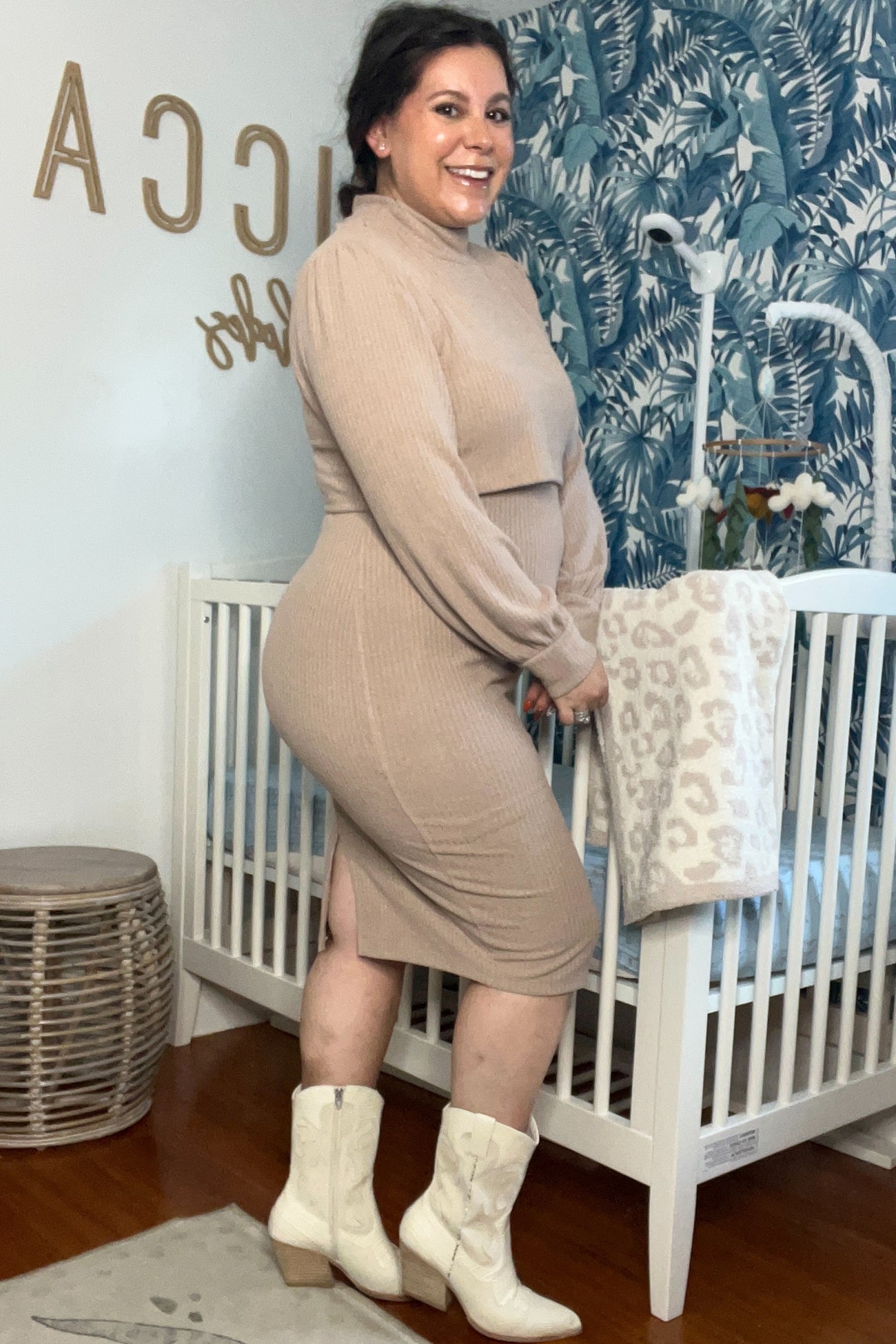 woman wearing a beige maternity dress with long sleeves, showcasing her baby bump, paired with white cowboy boots