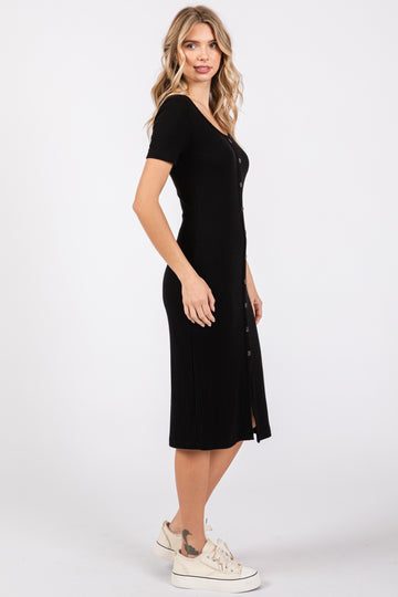 woman wearing a black ribbed midi dress with short sleeves and button details, standing sideways