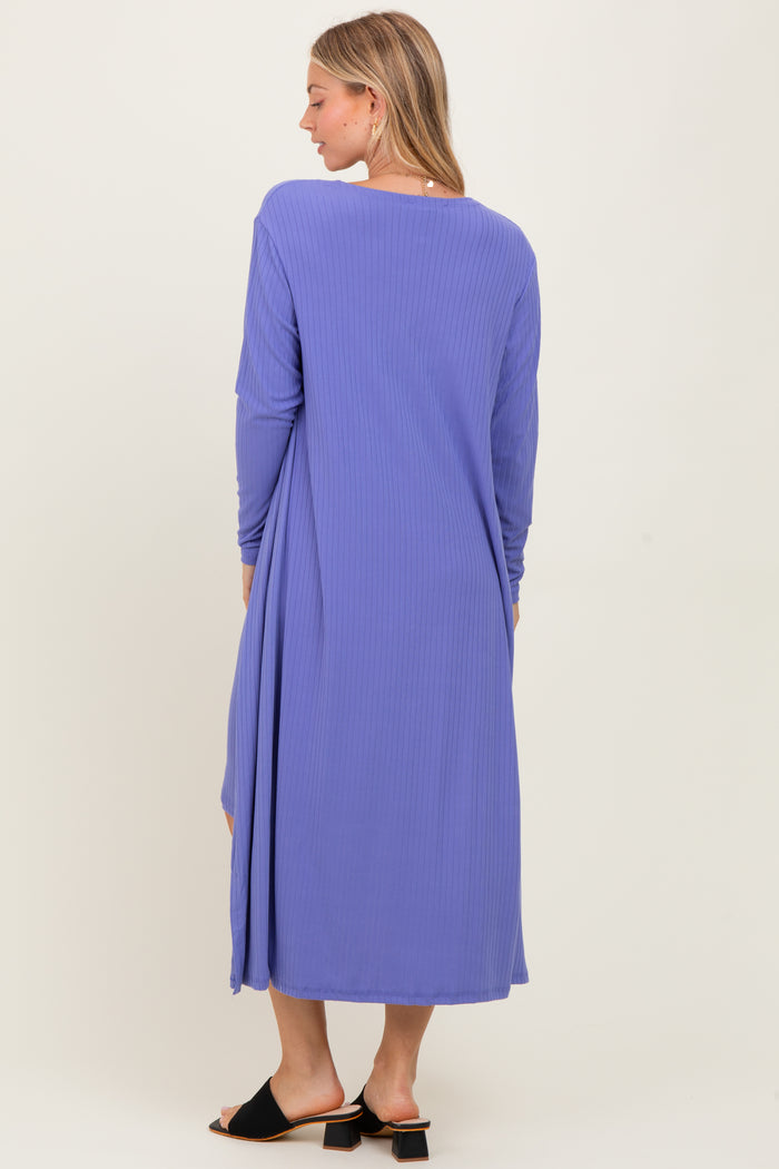 woman wearing a long purple ribbed dress with long sleeves and a relaxed fit, shown from the back