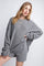 woman wearing a gray oversized ribbed sweater with long cuffs and styled with casual shorts