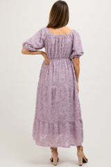 maternity wear in a lilac tiered maxi dress with puff sleeves and textured floral details, model shown from the back