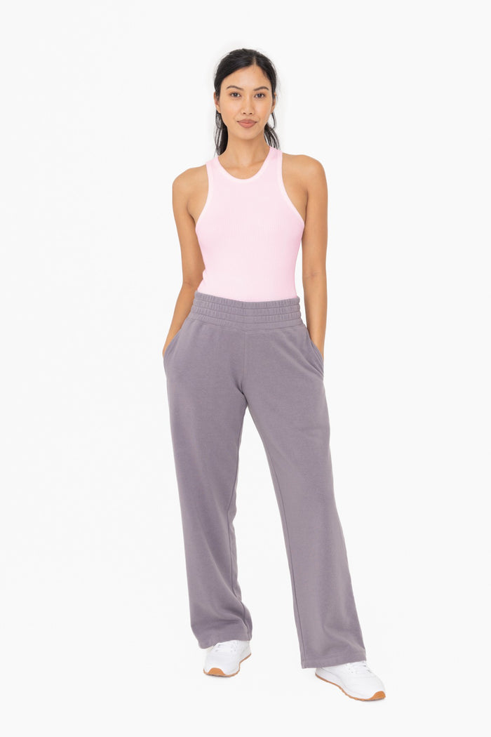woman wearing a pink ribbed tank top and gray wide-leg sweatpants with pockets