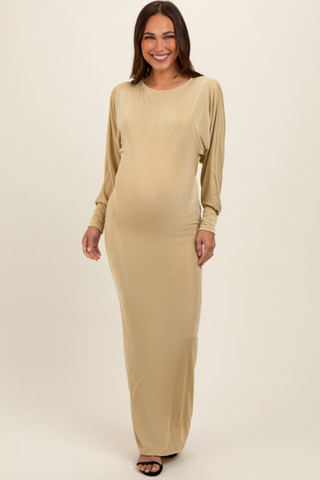 woman wearing a gold long sleeve maternity gown with a visible baby bump
