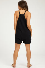 woman wearing a black maternity romper, showing a relaxed fit and adjustable straps from the back