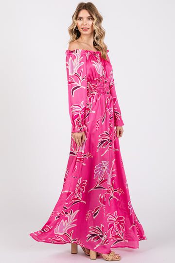 woman wearing a pink floral off-the-shoulder maxi dress with long sleeves and smocked waist