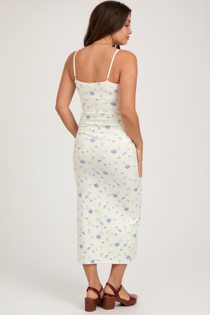 woman wearing a floral print maternity midi dress with spaghetti straps and a fitted silhouette