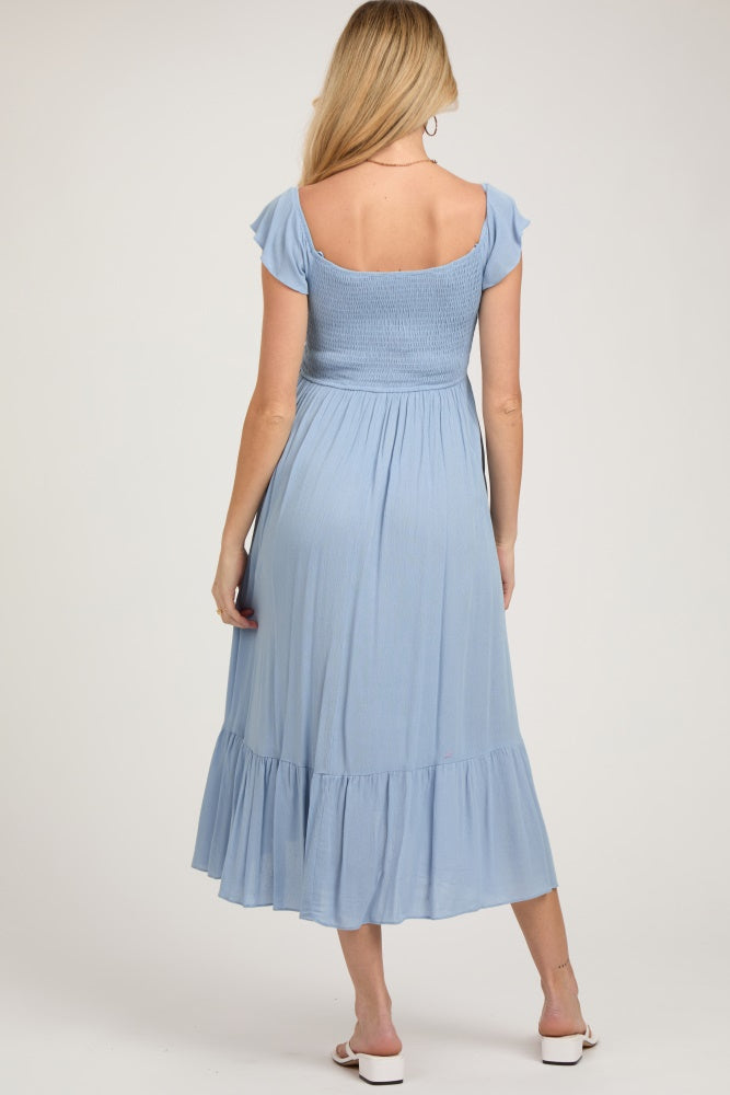 woman wearing a light blue maternity dress with short flutter sleeves and a flared skirt, shown from the back