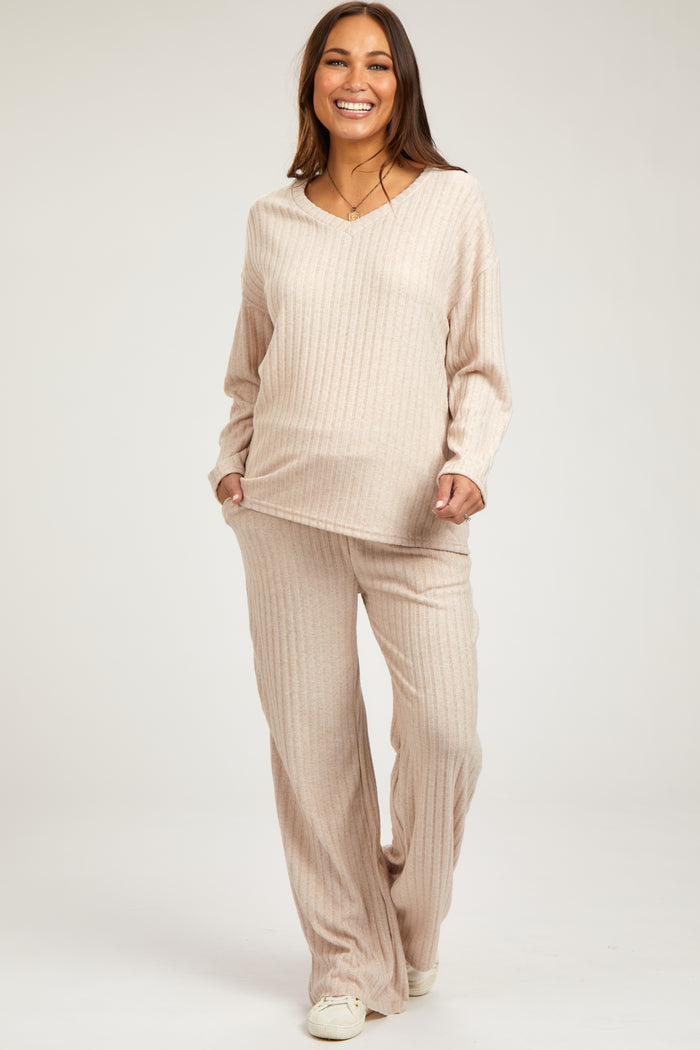 woman wearing a beige ribbed maternity lounge set with long sleeves and wide-leg pants, showcasing her baby bump
