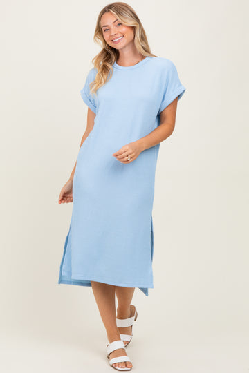 woman wearing a light blue ribbed midi dress with short sleeves and side slits