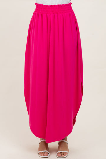 woman wearing a bright pink flowy maxi skirt with an elastic waistband and side pockets